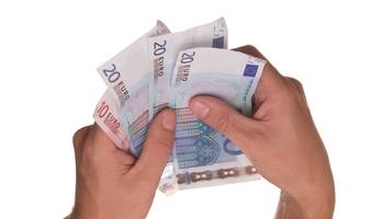 Symbolbild: Zwei Hände halten mehrere Geldscheine.